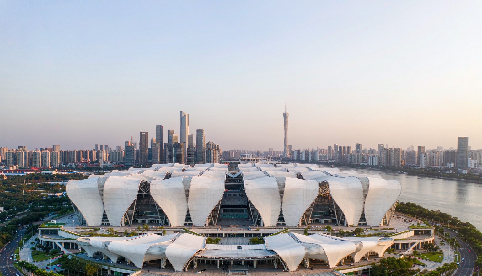 Exterior of the Pazhou Canton Fair Complex: exhibition halls along the Pearl River with metal roofs and large glass curtain walls