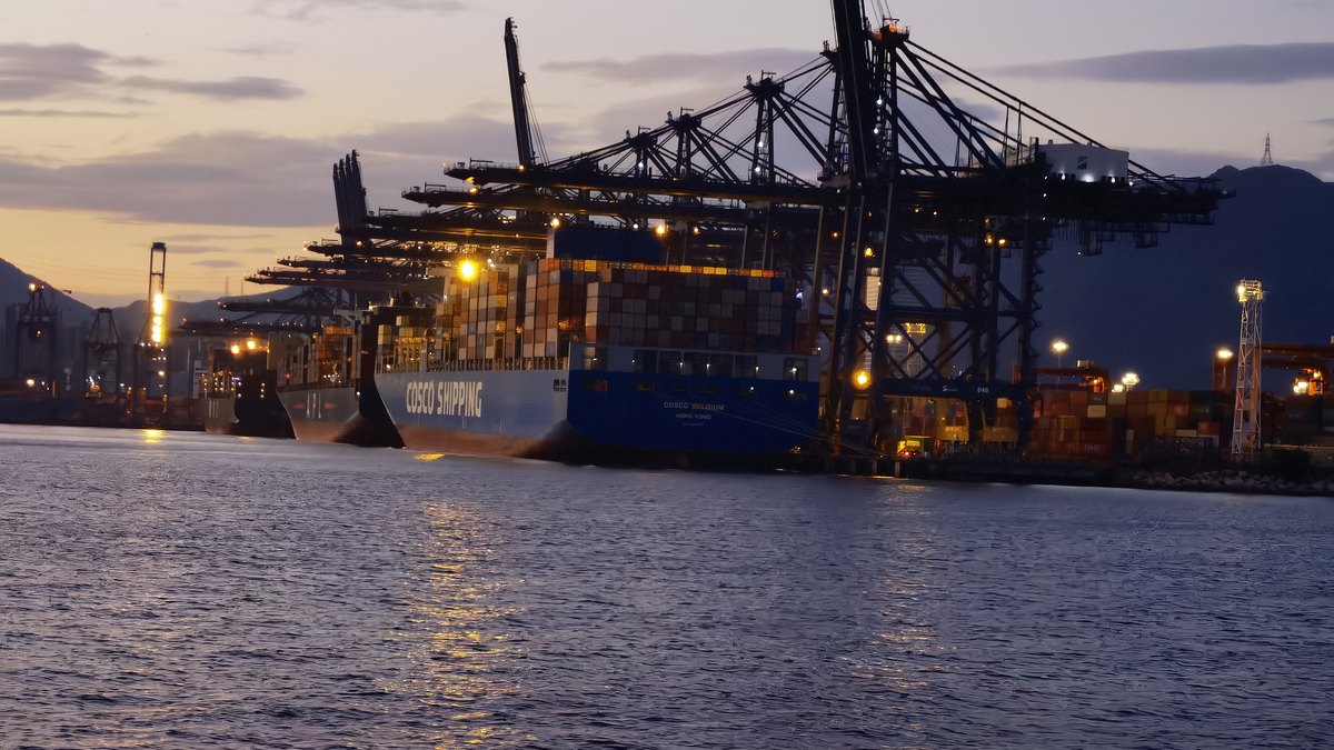 Container terminal cranes working at dusk &mdash; the kind of gateway Callao provides for Peruvian imports