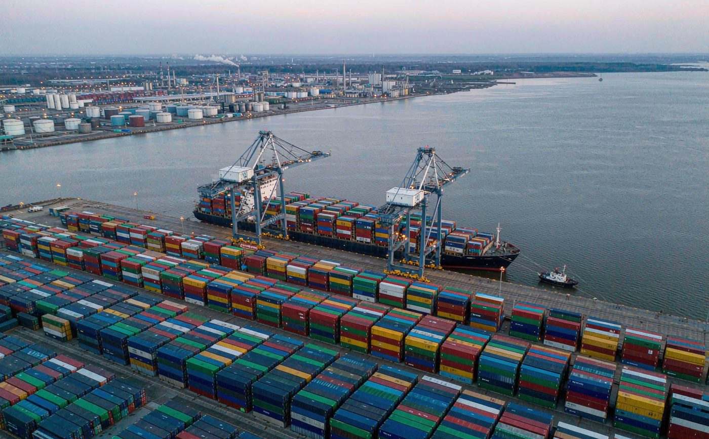 Container terminal at the Port of Antwerp-Bruges with ship-to-shore gantry cranes, stacked containers and a vessel berthed alongside