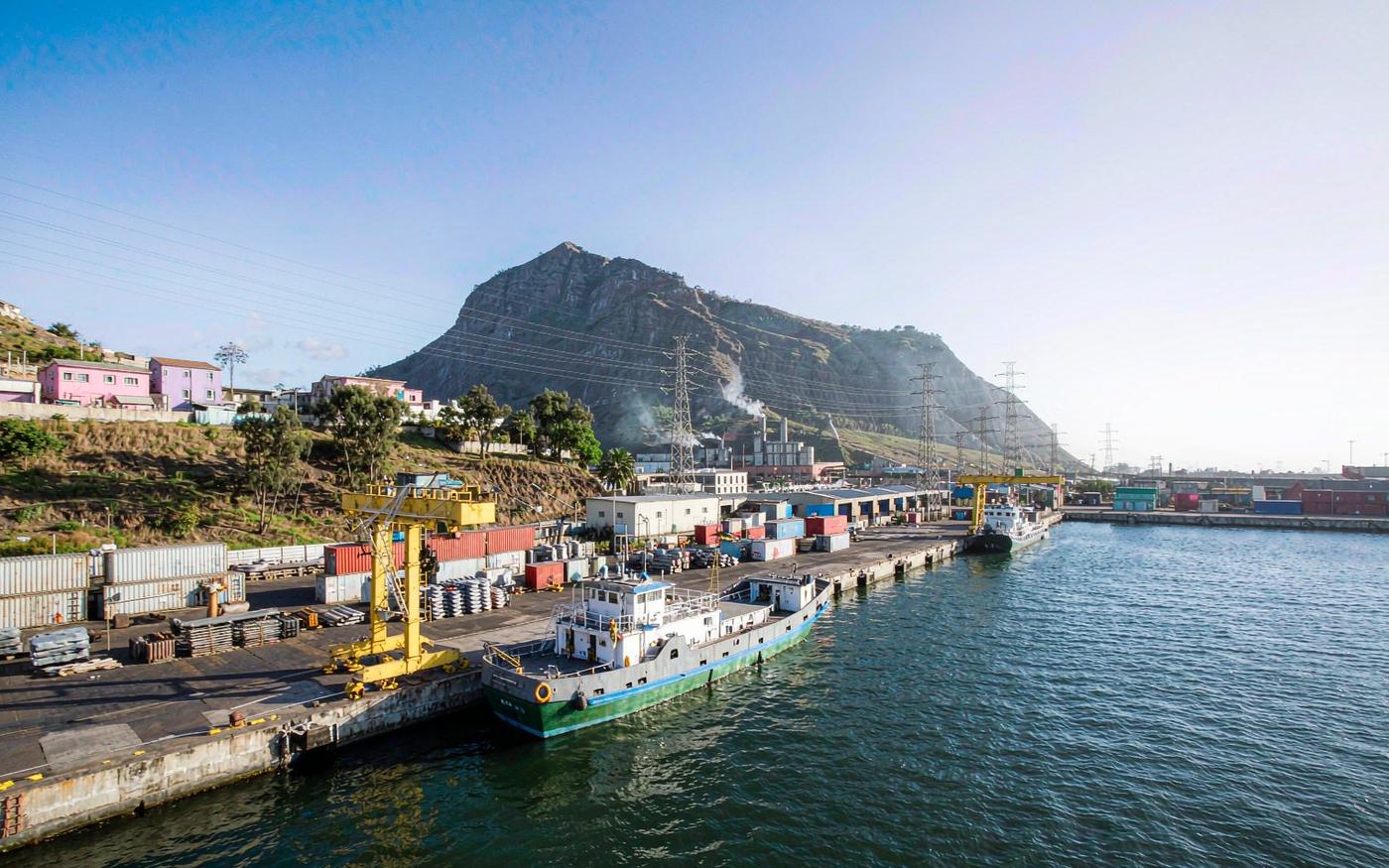Porto Grande harbour in Mindelo, Cape Verde, with container quay, feeder vessel and volcanic hills behind