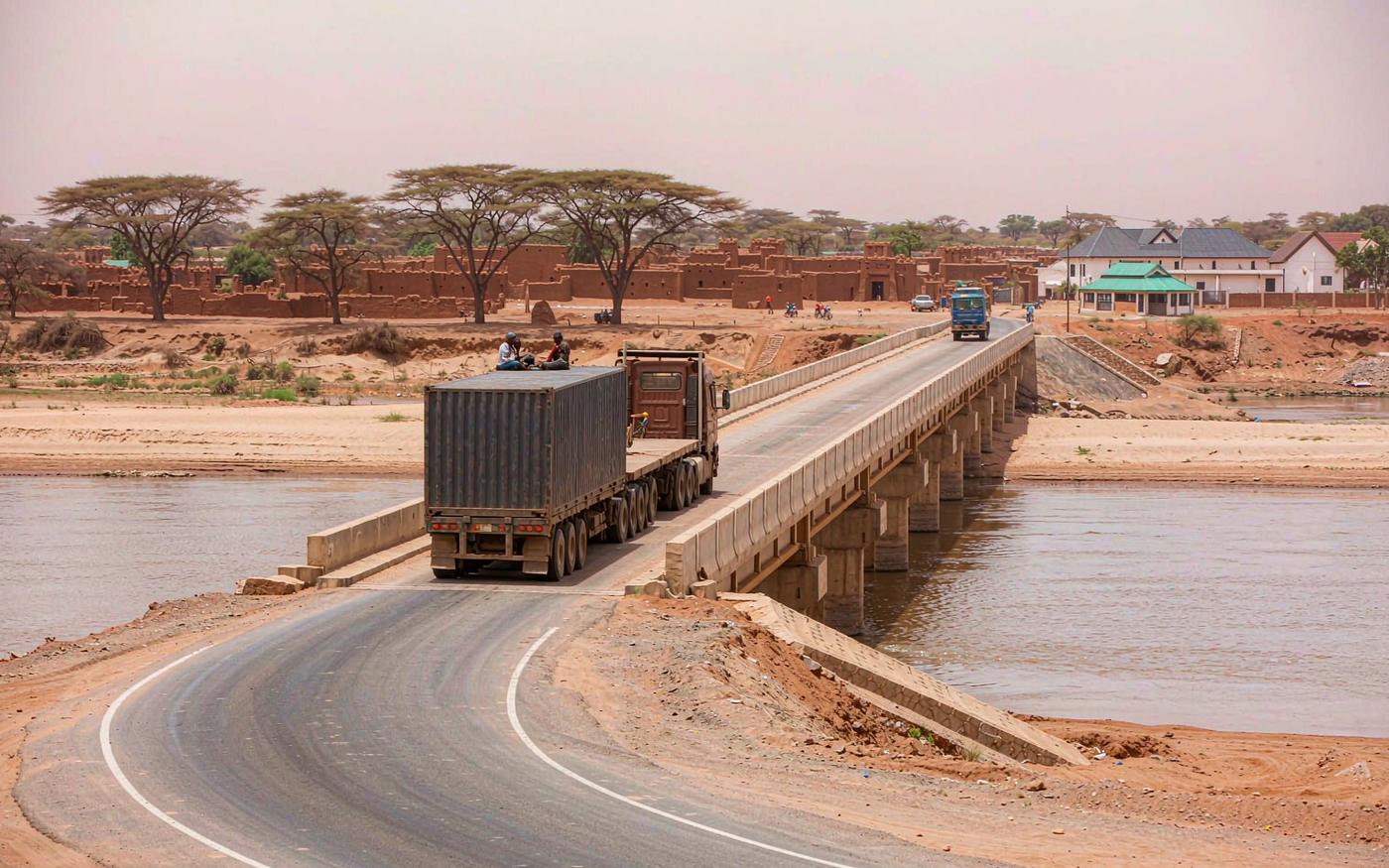 Heavy truck carrying a shipping container crossing a bridge over the Niger river at Bamako in Mali