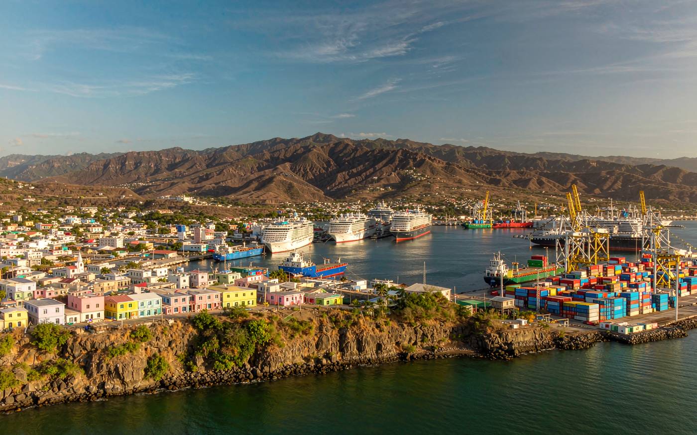 A Caribbean harbour city with a container terminal, a sheltered bay and green hills behind