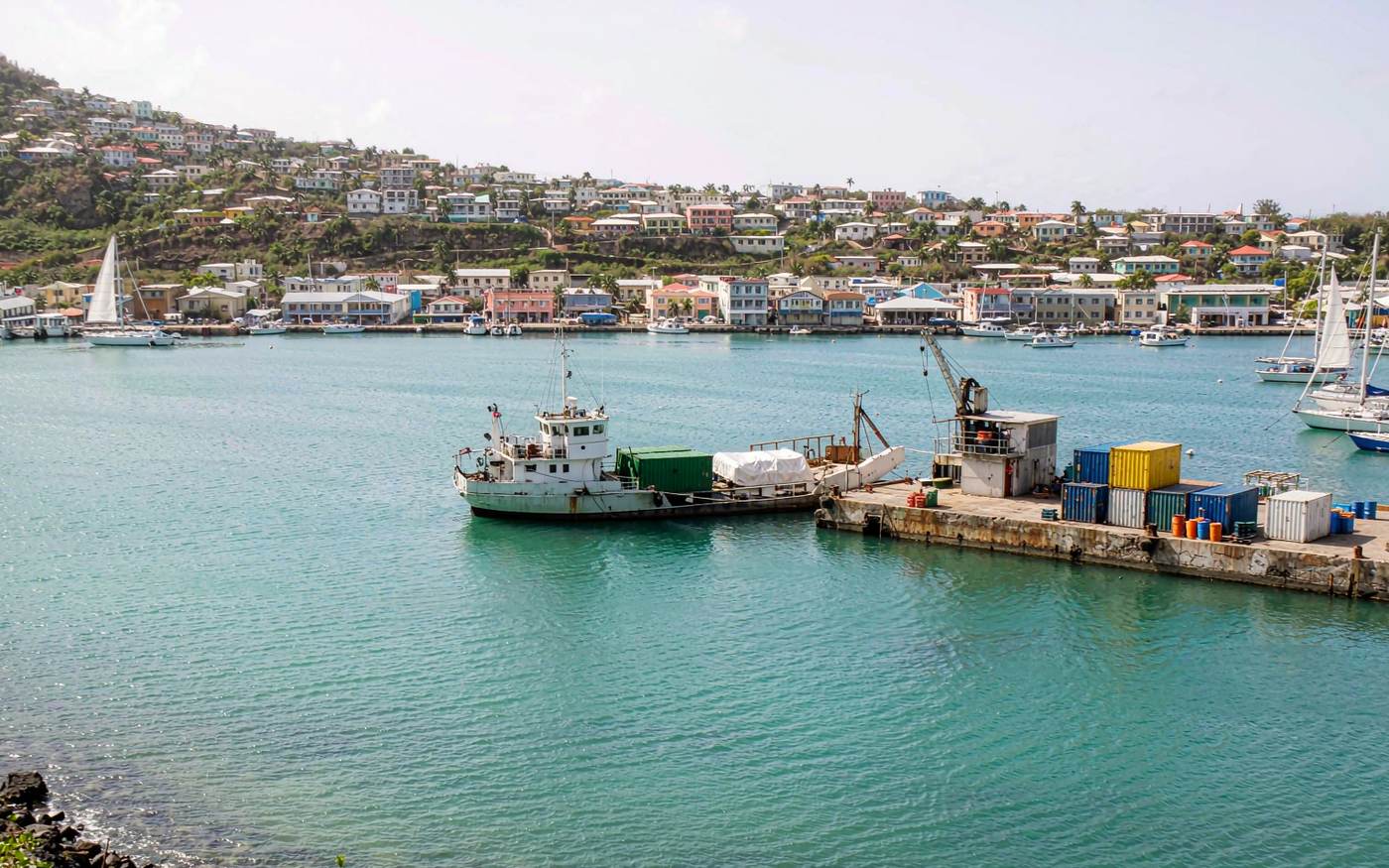 Small Caribbean harbour with a general cargo vessel alongside a short quay and a hillside town behind
