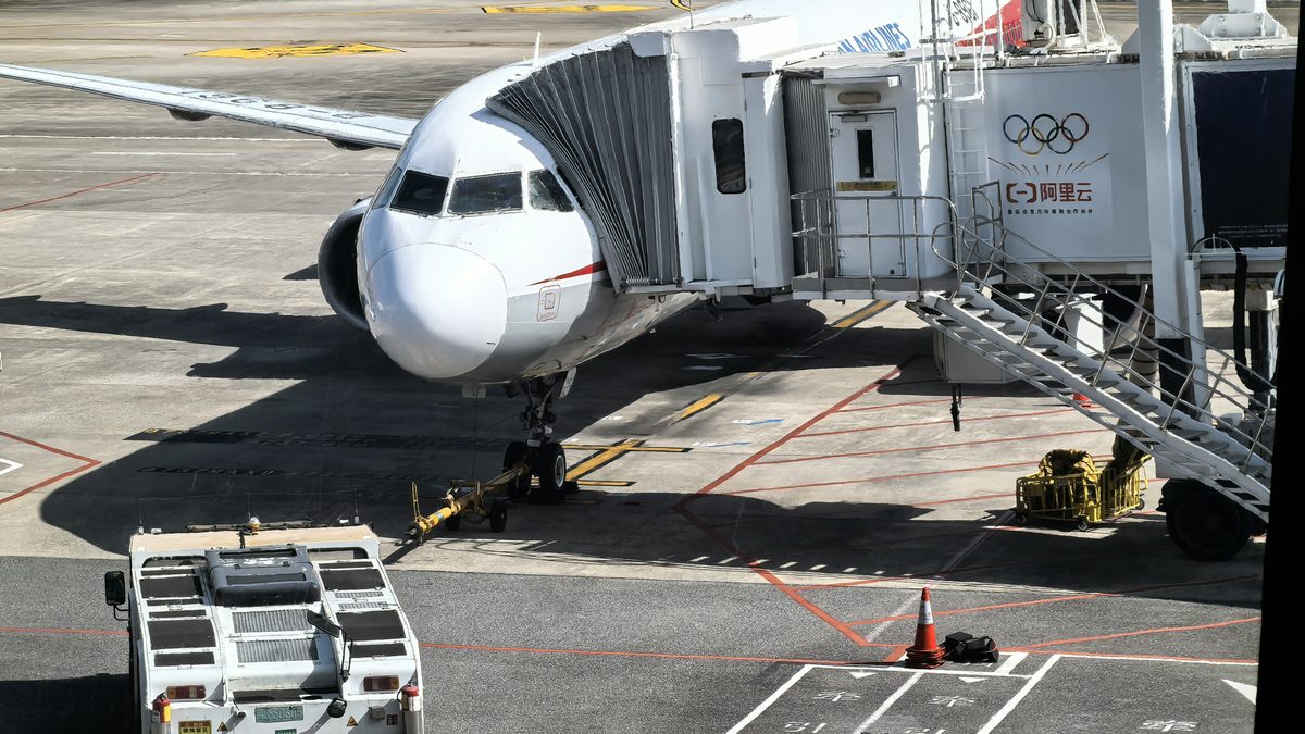 Aircraft at a gate with ground handling equipment at a Chinese airport &mdash; airport-to-airport air freight from China to the USA