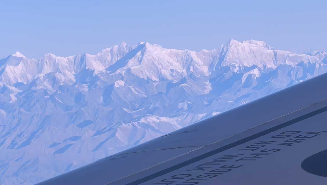 Aircraft wing seen from a passenger window above a snow-covered mountain range on a China to USA flight