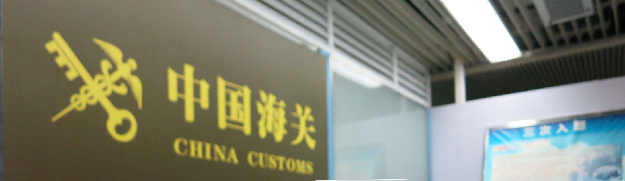 Golden sign reading China Customs in Chinese characters and English above a doorway at a Chinese port facility